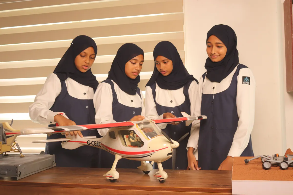 Four students examining a radio-controlled model aircraft together